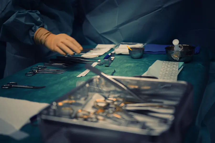 Fotografía de stock: instrumental quirúrgico esterilizado preparado sobre un paño verde en un quirófano.